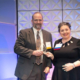 ATCS' Eric Mongelli accepting coprorate award on stage at an awards gala