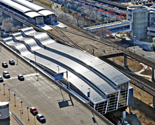 Aerial view of rail terminal connected to airport.