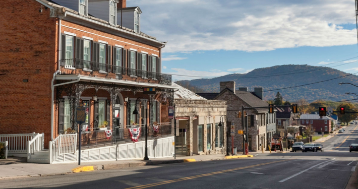 A street scene featuring a building on the left and a mountain rising in the background.