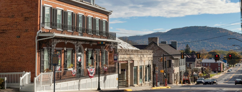 A street scene featuring a building on the left and a mountain rising in the background.