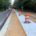 A sidewalk is under construction next to a road, with workers and equipment actively engaged in the building process.