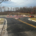 A road with a construction site and several cars parked on side of street