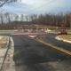 A road with a construction site and several cars parked on side of street