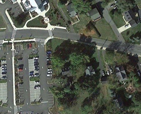 Aerial view of a road intersection filled with cars and adjacent parking lot