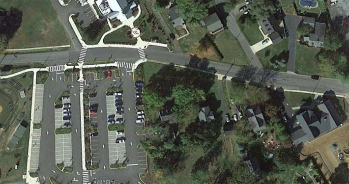 Aerial view of a road intersection filled with cars and adjacent parking lot